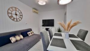 a living room with a table and a couch and a clock at Apartment Anka in Omiš