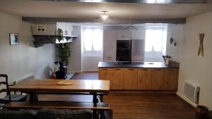 a kitchen with a wooden table and a wooden table sidx sidx sidx at Chez Célia in Laruns