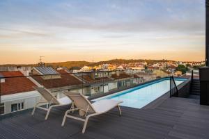einen Balkon mit 2 Stühlen und einem Pool in der Unterkunft Mirabilis Apartments - LX Living in Lissabon
