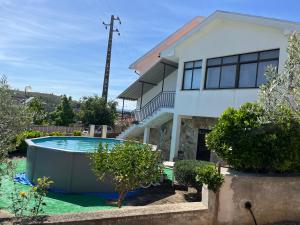 una casa con piscina frente a ella en Chelas Rural AL, en Mirandela
