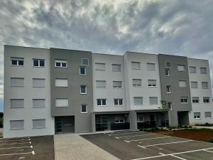 a large white building with a parking lot at Apartment Giò in Tar