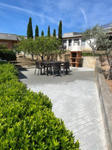 un patio con tavoli neri, sedie e alberi di Chelas Rural AL a Mirandela