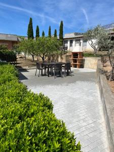 a patio with black tables and chairs and trees at Alojamento, Chelas Rural AL in Mirandela
