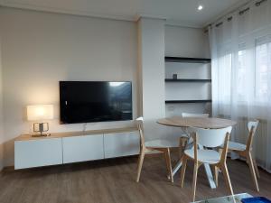 comedor con mesa y TV de pantalla plana en Apartamento Calzada Romana en Lugo