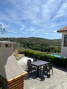 a table and chairs on a patio with a view at Alojamento, Chelas Rural AL in Mirandela