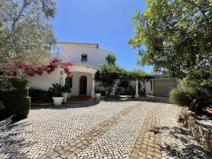 un vialetto di ciottoli di fronte a una casa bianca di Alvor Traditional Villa With Pool by Homing a Unhais da Serra
