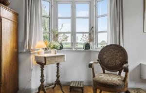 a chair in a room with a table and a window at Nice Home In Sønderborg With Kitchen in Sønderborg +23 photos