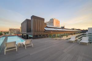 eine Dachterrasse mit Stühlen und einem Pool auf einem Gebäude in der Unterkunft Mirabilis Apartments - LX Living in Lissabon