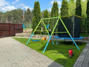 a playground with a swing set on the grass at Casa Georgea in Săcele