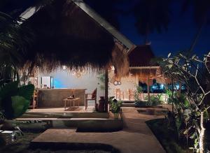 Cette maison dispose d'une terrasse avec une table et des chaises. dans l'établissement Penida Green Palm Cottage, à Toyapakeh