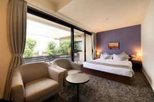 a hotel room with a bed and a chair and window at Hotel Tokyo Trip Ueno Nishi Nippori in Tokyo