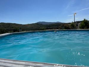 una piscina azul con montañas en el fondo en Chelas Rural AL, en Mirandela