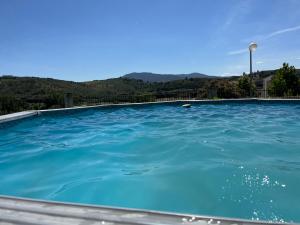 a blue swimming pool with mountains in the background at Alojamento, Chelas Rural AL in Mirandela
