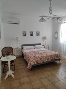 a bedroom with a bed and a table and a chair at Villaggio Imbesi in Villa San Giovanni