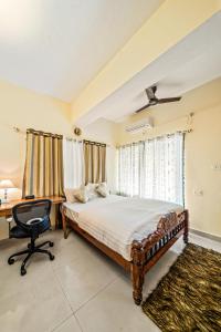 a bedroom with a bed and a desk and a chair at Ivory - Vintage Haven in Bangalore