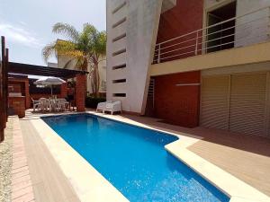 a swimming pool in front of a house at Sesimbra Charming Pool Duplex BBK & Garden in Sesimbra