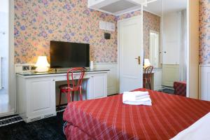 a room with a bed and a desk with a television at Hotel alla giustizia in Mestre