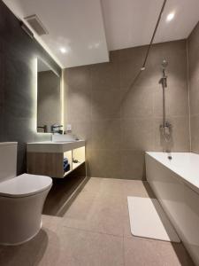 a bathroom with a toilet and a sink and a tub at May Seven Hotel and Suites in Ulaanbaatar +61 photos
