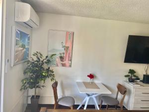 a dining room with a table and chairs and a tv at Free parking Comfy central Waikiki in Honolulu