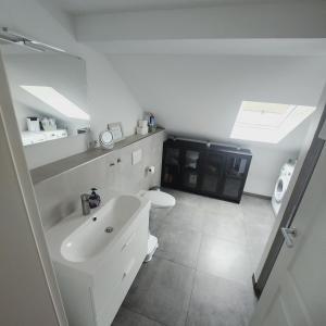 ein weißes Bad mit einem Waschbecken und einem WC in der Unterkunft Apartment Katarina Oberasbach in Oberasbach