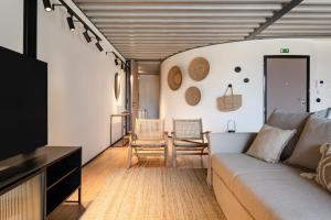 a living room with a couch and a tv at Feel Porto Matosinhos City Flats in Matosinhos