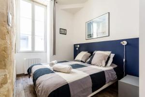 a bedroom with a large bed with a blue headboard at Lurbe Bleue - Bordeaux central et calme in Bordeaux