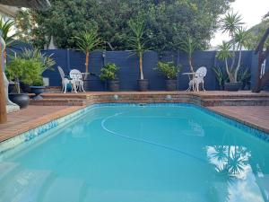 a swimming pool with two chairs and a table at Loddey`s Guest House - by Beach Collection in Strand