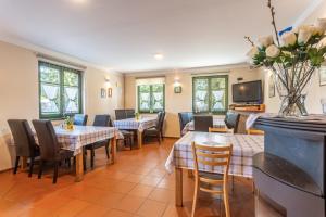 a dining room with tables and chairs and a tv at Houda Bouda - Penzion & Apartmány in Boží Dar