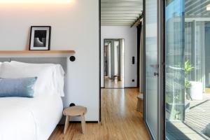 a bedroom with a bed and a sliding glass door at Feel Porto Matosinhos City Flats in Matosinhos