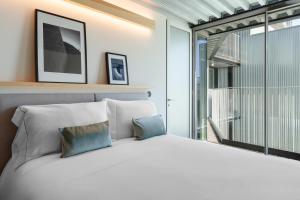 - une chambre avec un lit blanc et un balcon dans l'établissement Feel Porto Matosinhos City Flats, à Matosinhos