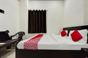 een slaapkamer met een bed met rode en witte kussens bij OYO Pari Residency in Jaipur
