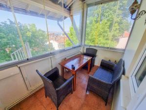 a table and chairs in a room with windows at White Palace Büyükada in Adalar