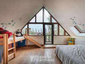 a bedroom with a large window in a attic at Grande Maison familiale in Maillebois