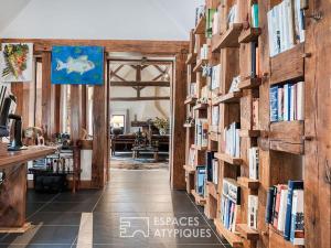 a hallway with bookshelves filled with books at Grande Maison familiale in Maillebois