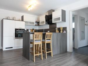 a kitchen with white cabinets and a table and chairs at ELYs-Home in Isny im Allgäu