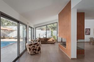 a living room with a couch and a pool at Grand Apollon Villa in Sounio