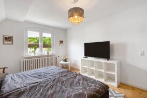 um quarto com uma cama e uma televisão de ecrã plano em Ferienhaus Waldliebe em Hüttenrode