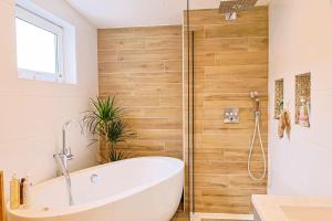 a bathroom with a white tub and a shower at Maison proche Disney in Chennevières-sur-Marne