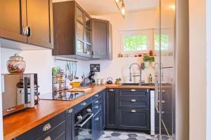 a kitchen with blue cabinets and a sink at Maison proche Disney in Chennevières-sur-Marne