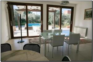 a dining room with a glass table and chairs at Villa delle Muse in Marsala