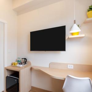 a room with a desk with a television on the wall at Bloom Hotel - HSR Layout Sec 6 in Bengaluru