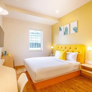 a bedroom with a large bed with a yellow headboard at Bloom Hotel - HSR Layout Sec 6 in Bengaluru