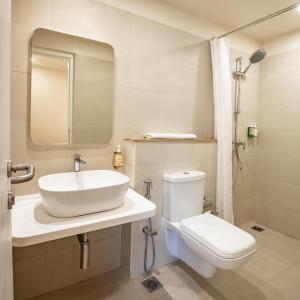 a white bathroom with a sink and a toilet at Bloom Hotel - HSR Layout Sec 6 in Bengaluru