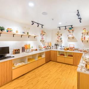 a kitchen with wooden cabinets and shelves at Bloom Hotel - HSR Layout Sec 6 in Bengaluru