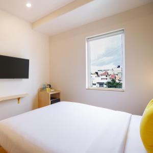 a bedroom with a bed and a window at Bloom Hotel - HSR Layout Sec 6 in Bengaluru