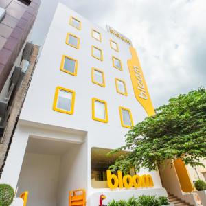 a white building with a yellow sign on it at Bloom Hotel - HSR Layout Sec 6 in Bengaluru