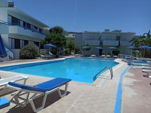 una grande piscina con sedie e ombrelloni di Kosinmyheart Apartment 11 & Studio10 a Città di Kos
