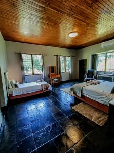 Linvale Country Lodge في هازيفيو: غرفة نوم بسريرين وسقف خشبي
