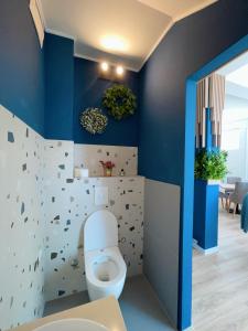 baño con aseo blanco y paredes azules en Apartments and rooms SMILE en Mostar