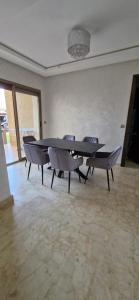 un comedor con mesa y sillas en una habitación en très belle maison avec jardin et piscine, en Saidia 